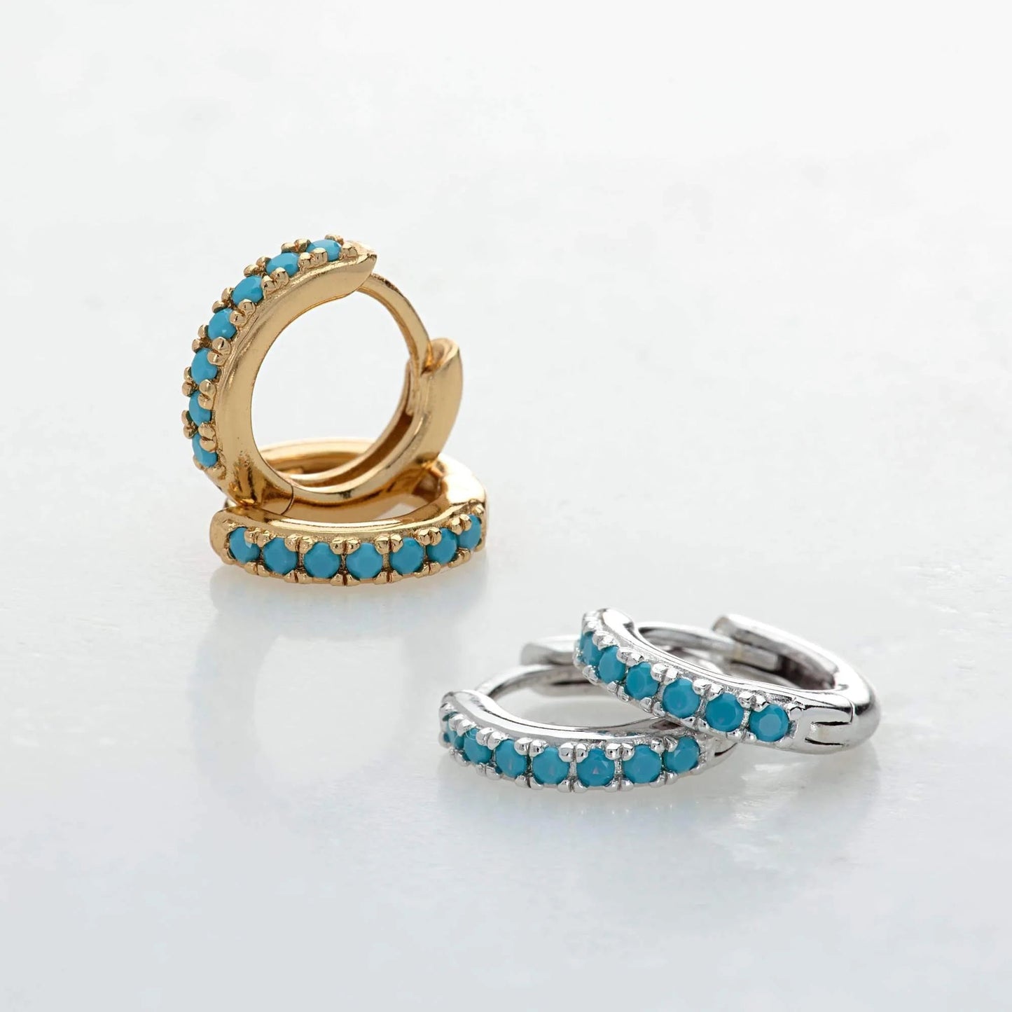 Gold and silver Row Huggies Earrings with turquoise stones on grey background - IceGlint