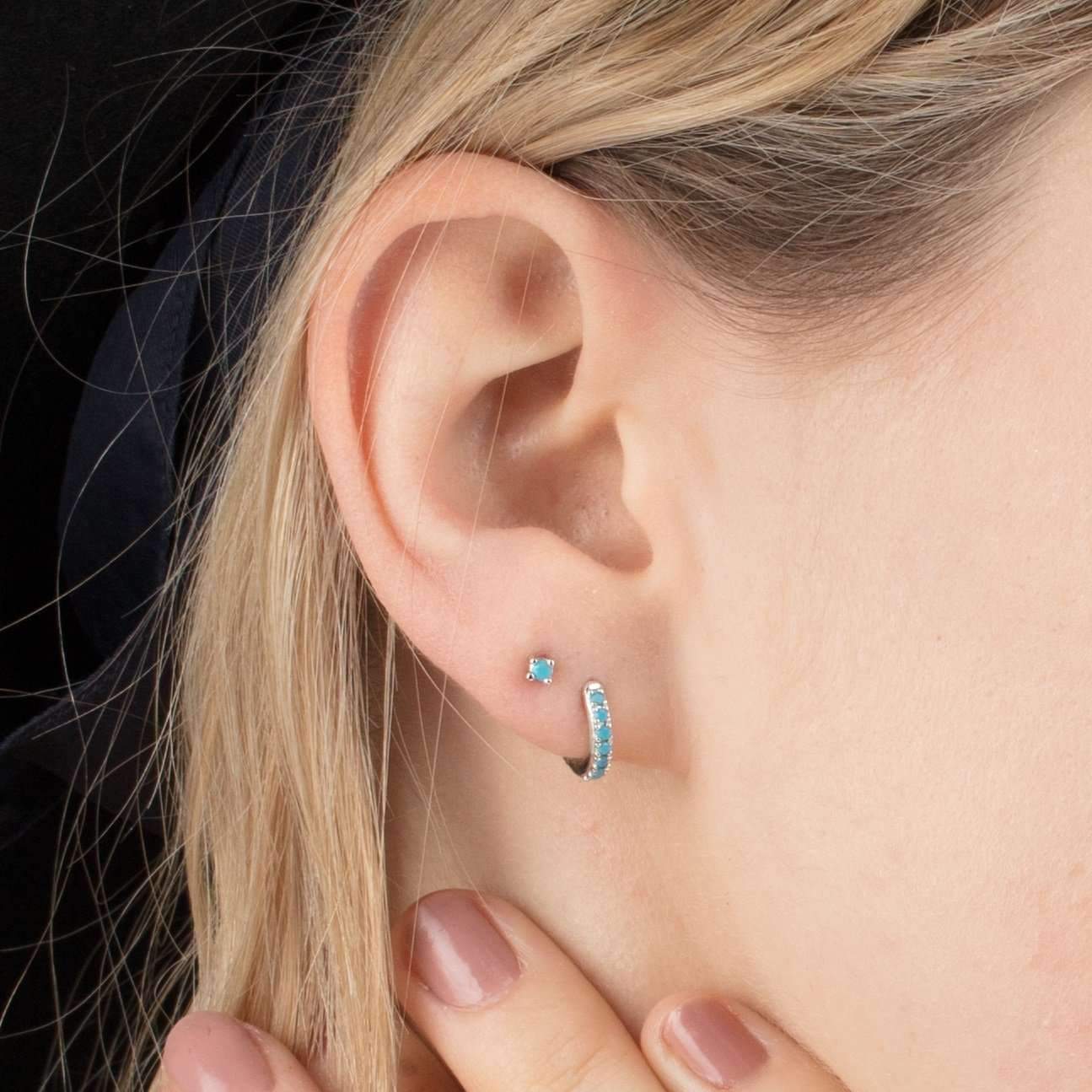 Blonde model showcasing silver Row Huggies Earrings with turquoise stones in her ear - IceGlint